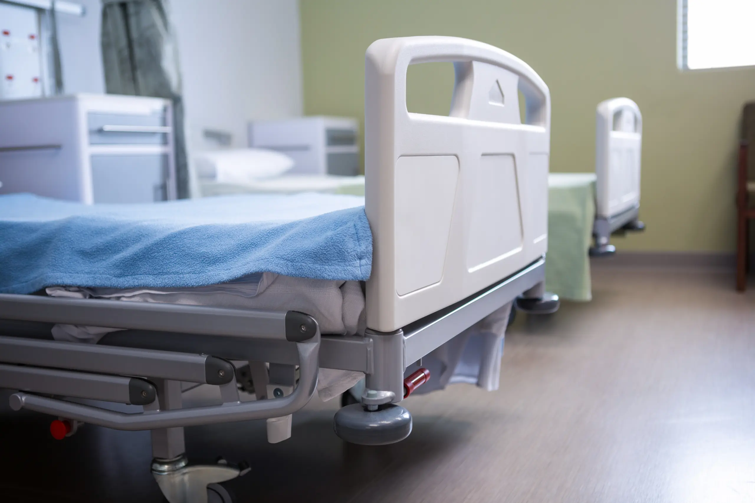 Two empty hospital beds in a patient room