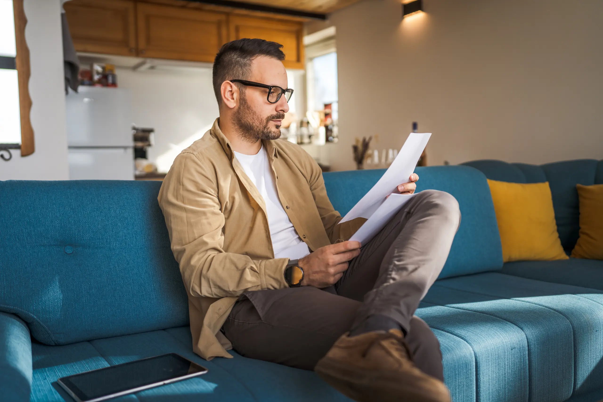 Man reviewing paperwork while seated at home